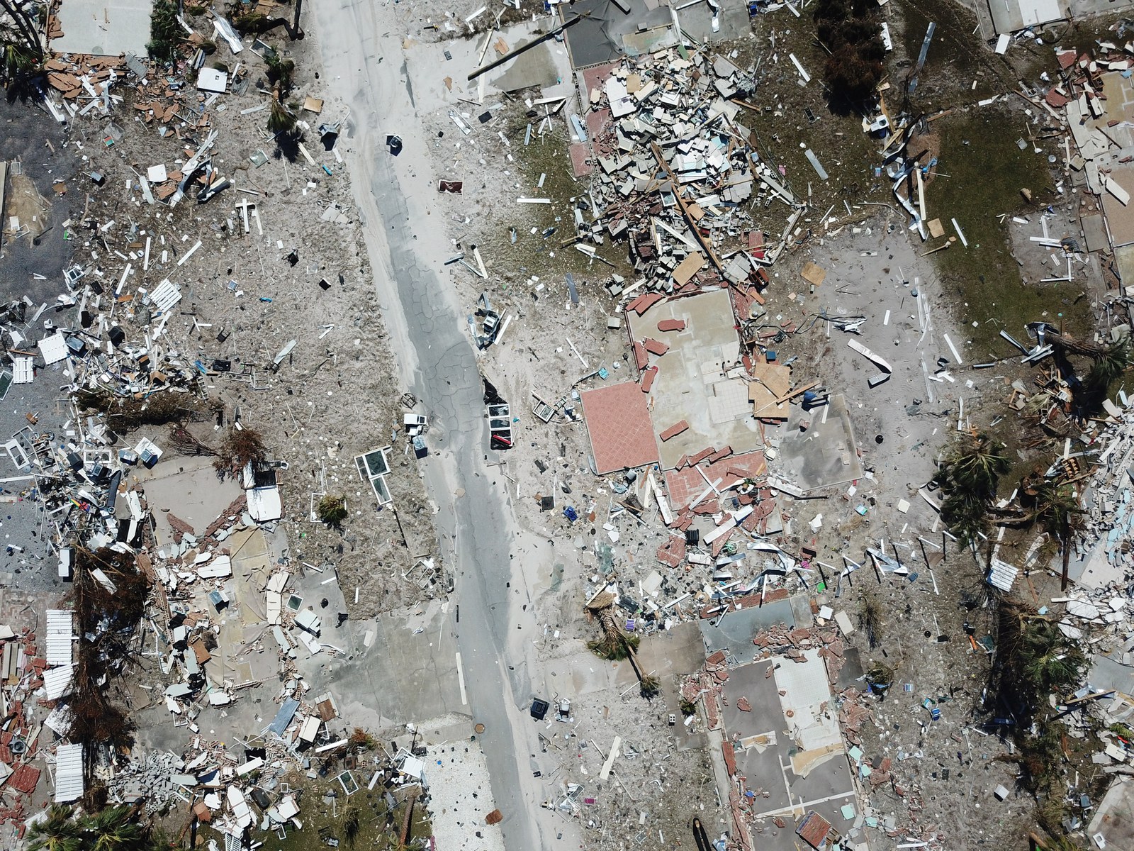 Aerial view of hurricane or earthquake damage across a residential neighborhood